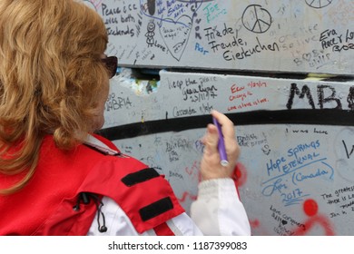 Belfast, Northern Ireland - February 17 2018: A Women Writes On The Wall Of Peace In Belfast Commemorating The Violence That Happened In Northern Ireland. The Wall Is A Tribute To The Troubles.