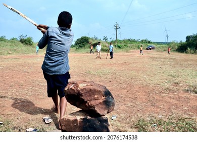 Belgaum, Karnataka, India - Nov 7, 2021: A Young Indian Village Boy Is Batting During A Gully Cricket Game.