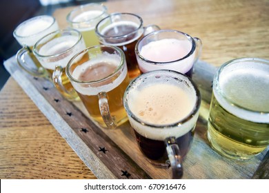 Belgian Beer Flight On Wooden Table In Bar