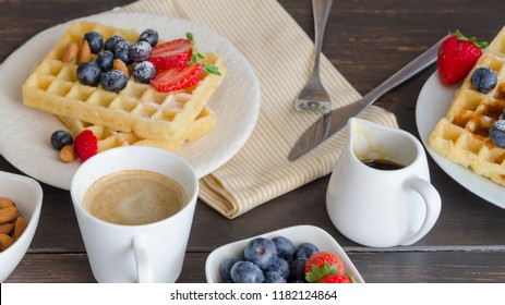 Belgian waffle decorated  with strawberries,  blueberries and almond on wooden table for perfect  breakfast at Sunday. Homemade dessert background. Relax moments concept and lifestyle image