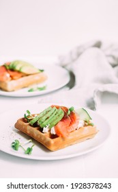 Belgian waffles with salmon, avocado and cream cheese on a white plate. Healthy breakfast