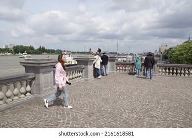 Belgium, Antwerp, May 26, 2022. The elevated Zuiderterras near the river Scheldt (Schelde). Tourists watch and photograph the river. Spring in the city of Antwerp.