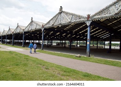 Belgium, Antwerp, May 26, 2022. Metal open sheds, hangars, rivet connections, gable roofs with corrugated iron, pediment with incised plant motifs. Quay at the river Scheldt in the Belgian city