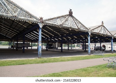 Belgium, Antwerp, May 26, 2022. Metal open sheds, hangars, rivet connections, gable roofs with corrugated iron, pediment with incised plant motifs. Quay at the river Scheldt. Belgian city of Antwerp