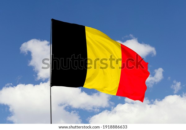 Belgium flag\
isolated on the blue sky with clipping path. close up waving flag\
of Belgium. flag symbols of\
Belgium.