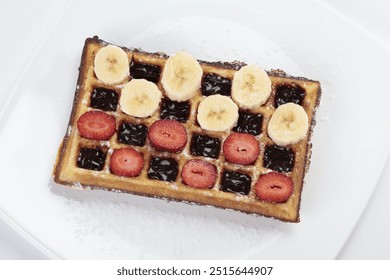 Belgium waffle with banana and strawberries slices on white plate  - Powered by Shutterstock