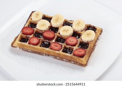 Belgium waffle with banana and strawberries slices on white plate  - Powered by Shutterstock