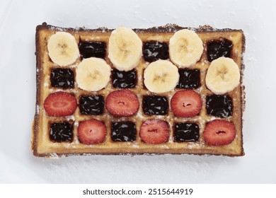 Belgium waffle with banana and strawberries slices on white plate  - Powered by Shutterstock