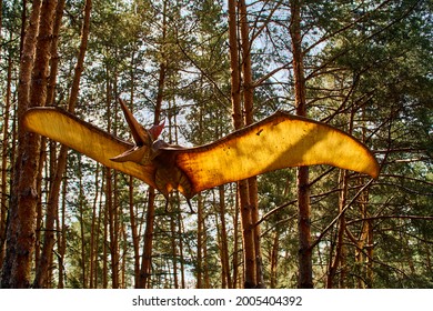 Belgorod, Russia May 27, 2021 Dino ParkPteranodon among rays of sun in pine forest. flying dinosaur pterodactyl spreads its wings and flies. Monster large lizard of Mesozoic era flies in green forest 