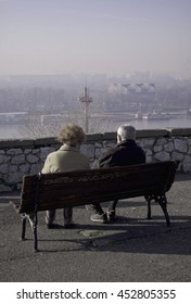 Belgrade, Serbia - 14th Of December 2014 - Elderly Couple Resting And  Watching Sunrise On The Bench