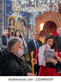 Belgrade, Serbia, 31 Oct 2021: Orthodox Church of Holy Trinity. Baptism of a child. Mother is holding a child in the background
