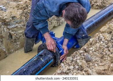 BELGRADE, SERBIA - DECEMBER 23: Close up of installing water pipe valve in a trench. Laying a water pipeline, working on water valves. Selective focus. At construction site in December 2014. 