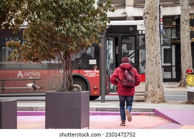 BELGRADE, SERBIA - FEBRUARY 14, 2021: Selective Blur On A Young Man Running To Catch A Bus, Being Late While The Public Transportation Is Punctual At A Bus Stop In Belgrade Center.

