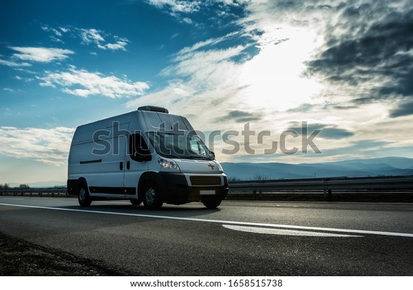 Belgrade, Serbia - February 21,\
2020. Ambulance van transporting a patient driving through highway\
on bright sunny sunset. Medical Transportation\
vehicle