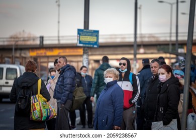 BELGRADE, SERBIA - FEBRUARY 28, 2021: Selective Blur On A Senior Old Woman In A Crowd Of People Waiting A Bus At A Stop In Belgrade Wearing Facemask On Coronavirus Covid 19 Crisis.

