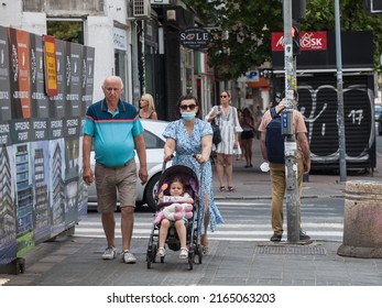 BELGRADE, SERBIA - JULY 4, 2021: Selective Blur On A Family, Grandfather, Grandmother, Senior, And Their Grandchild,  In A Stroller, Walking Wearing Face Mask Protection On Coronavirus Covid 19 Crisis