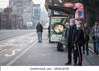 BELGRADE, SERBIA - NOVEMBER 8, 2020: Father And His Daughter, Waiting Their Bus At A Stop In Belgrade Wearing Face Mask Protective Equipement On Coronavirus Covid 19 Crisis.

