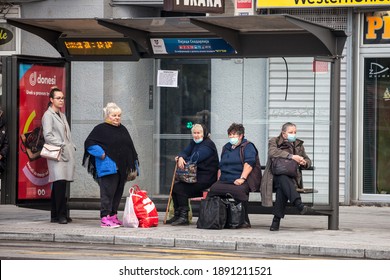 BELGRADE, SERBIA - OCTOBER 17, 2020: Old Senior Woman Wearing A Respiratory Face Mask Waiting For Transportation At A Bus Stop Of Belgrade During Coronavirus Covid 19 Crisis.

