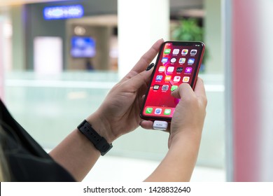 Belgrade, Serbia - October 26, 2018: New Apple iPhone XR mobile smartphone is displayed with apps on the screen in hand. Finger typing on digital gadget in electronic store.
