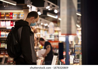 BELGRADE, SERBIA - OCTOBER 27, 2020: Male Client, A Girl, Choosing A Book In A Bookstore Wearing A Respiratory Face Mask In Belgrade, During The Coronavirus Covid 19 Health Crisis.

