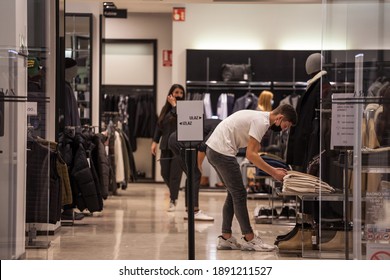 BELGRADE, SERBIA - OCTOBER 27, 2020: Staff Worker Employee Folding Clothes In A Fashion Retailer Clothing Shop Wearing A  Respiratory Face Mask In Belgrade, On The Coronavirus Covid 19 Health Crisis