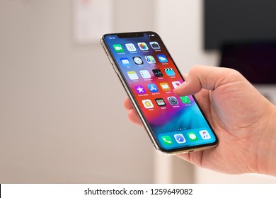 Belgrade, Serbia - October 31, 2018: New Apple iPhone XS mobile smartphone is displayed with apps on the screen in hand. Finger typing on digital gadget in electronic store.