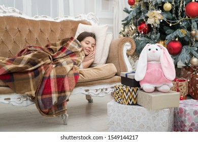 Believe In Miracles. Magical Moment. Christmas Night. Happy New Year. Little Girl Sleep Couch Near Christmas Tree Classic Interior. Family Holiday. Christmas Tree And Presents. Dreaming About Gifts.