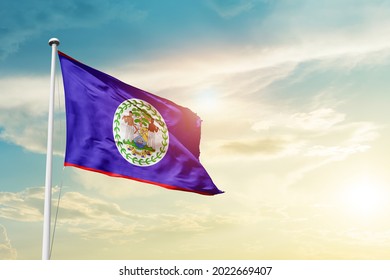 Belize national flag waving in beautiful clouds.