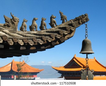 A bell and animal figurine ornaments at a traditional roof eave of a Chinese buddhist temple in Dali city in Yunnan Province, China.