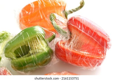 Bell Pepper With Cling Film Or Plastic Food Wrap On White Background.