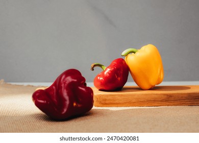 Piment de cloche de différentes tailles sur un plateau en bois. Arrière-plan jardin, récolte de tomates et de poivrons. Vue frontale : photo de stock