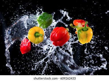 Bell peppers peppers with splash isolated on black background, motion action.