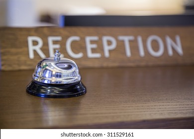 Bell With Reception Sign On Front Desk In Hotel. Made With Shallow Depth Of Field, Focus On Service Bell.