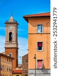 The bell tower of Chiesa di San Ferdinando stands between buildings in Livorno, Italy.