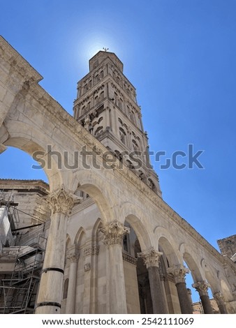 The bell tower of Diocletian's Palace in Split, Croatia, rises majestically with its Romanesque architecture, carved stone details and arched windows adorn the structure.
