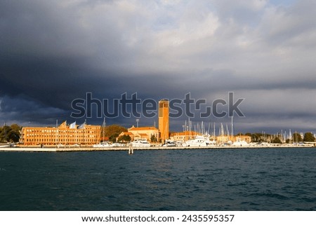 Bell tower of Sant'Elena Church and yacht harbor at extreme east end of sestiere of Castello in Venice, Italy. View from Venetian lagoon in stormy weather with dark cloudy sky in background. Foto stock © 
