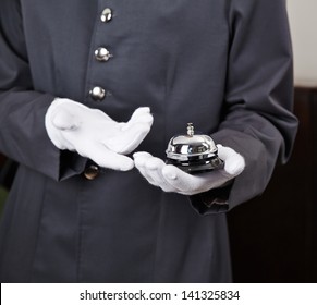 Bellboy Holding Bell In Hotel On His Hand