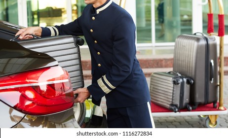 Bellboy taking baggage of guest from thee car to his room