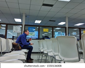 Bellevue, WA USA - November 1st, 2019: Bellevue DMV Waiting Room With White Chairs And A Man Sitting Waiting.