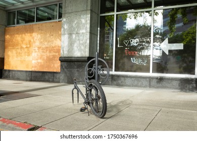 Bellevue, Washington / USA - June 1 2020:  Stolen Bike Locked To A Bicycle Rack On A City Street With Boarded Up Windows