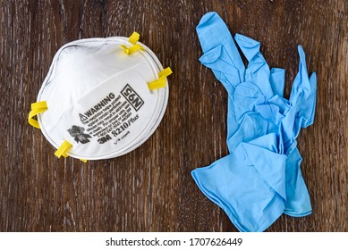 BELLEVUE, WA/USA – APRIL 18, 2020: PPE Safety Supplies On A Wood Table, 3M 8210Plus N95 Masks And Disposable Nitrile Gloves
