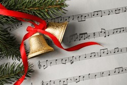 Bells And Fir Tree Branches On Music Sheet, Flat Lay. Christmas Decor