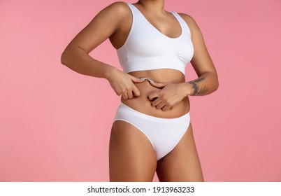 Belly anti-cellulite. Beautiful body of young african-american woman isolated on pink studio background. Fit, healthy and strong body. Natural beauty, treatment, healthcare, fitness and diet concept.