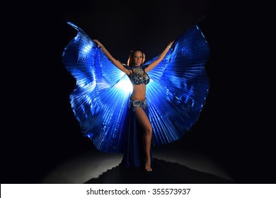 Belly Dancer Girl In Bright Blue Costume Against Darkness