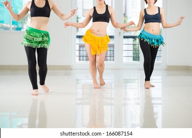 Belly dancers shaking their hips while performing in the dance hall