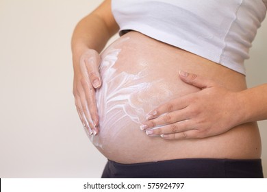 Belly of pregnant woman and moisturizing cream for stretch marks