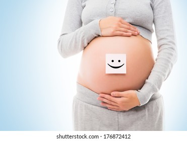 Belly of a young pregnant woman with a white sticker on it