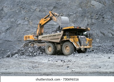 BELOGORSK, RUSSIA - JUNE 22, 2014: Excavator loads ore in a dumper in the background of a bench slope.
The mine is located in the village of Belogorsk, Kemerovo region. Siberia, Russia