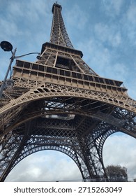 “Seen from below, the Eiffel Tower rises with elegance, guiding the eye upward into the Parisian sky.”
