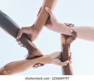 Below, hands and team, sports and collaboration, partnership and huddle against sky background. Bottom, fitness and friends hand in support of teamwork, goal and mission, diversity and training - Shutterstock ID 2256069797